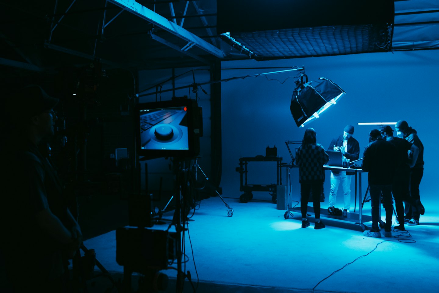 Professionisti della produzione multimediale che collaborano attorno a un tavolo con un laptop.
