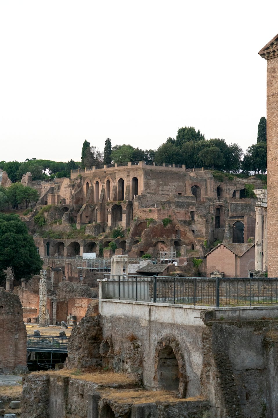 Antiche rovine romane con archi in pietra si trovano sotto una collina.