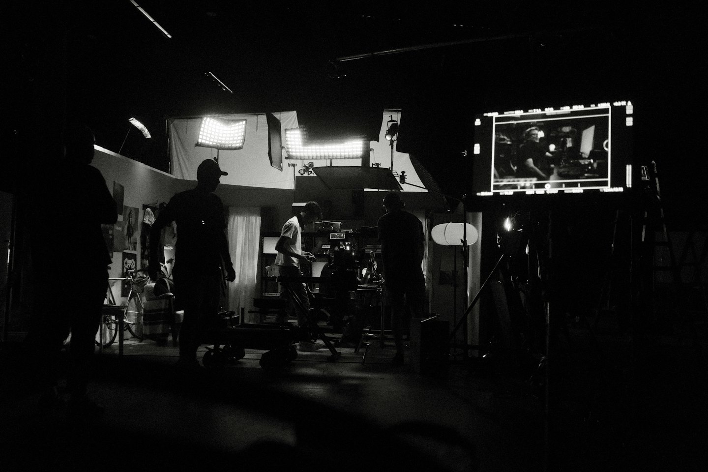 Troupe cinematografica in silhouette al lavoro su un set di produzione con attrezzature.